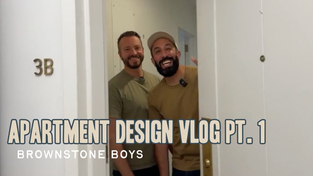 Two men opening a door inside an apartment building with text overlay saying "Apartment Design Vlog Pt. 1: Brownstone Boys"