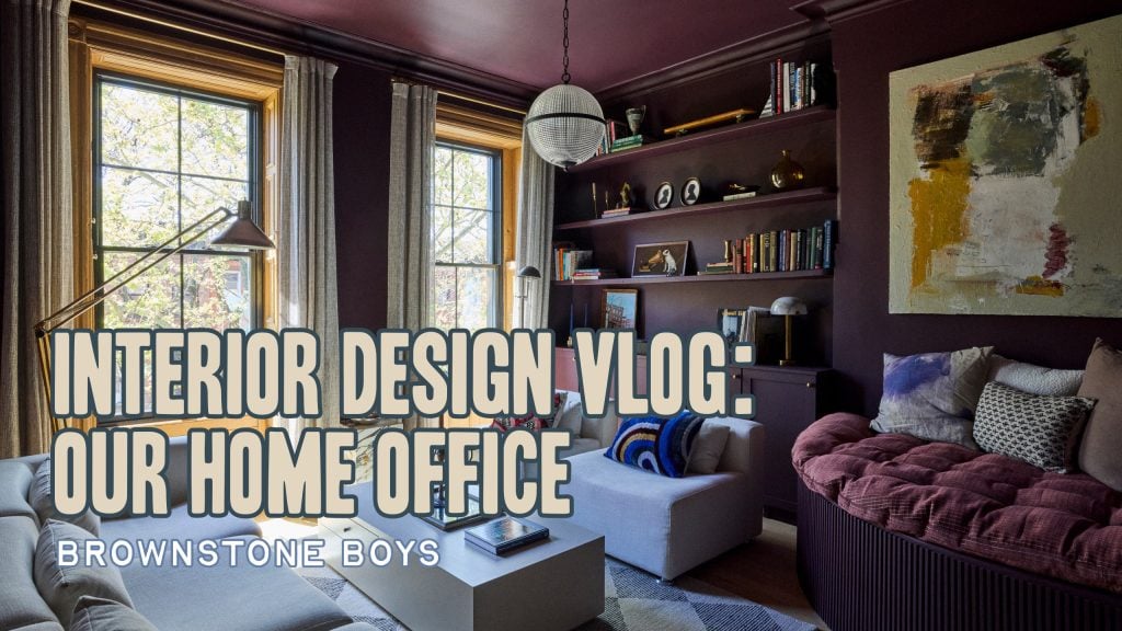 Room painted dark purple with two windows and a book shelf behind the sofa